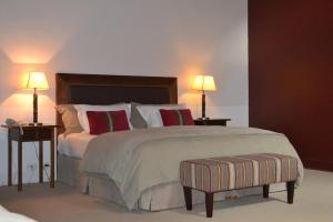 a bedroom with a large bed with two tables and two lamps at Loi Suites Chapelco Hotel in San Martín de los Andes