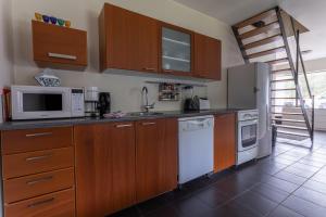 a kitchen with wooden cabinets and white appliances at Guesthouse Dalbaer in Fludir