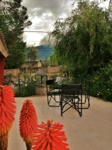 un patio con una mesa y sombrillas de papel rojo en Cabañas La Maria Lourdes en Tafí del Valle