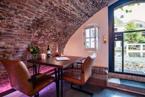a dining room with a table and chairs and a brick wall at UKI-Hotel in Utrecht