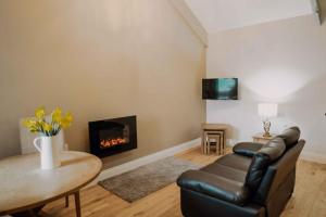 a living room with a couch and a fireplace at Dunlin in Belford