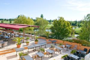an overhead view of a patio with tables and chairs at Mercure Toulouse Aéroport Golf de Seilh in Seilh