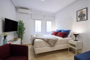 1 dormitorio con 1 cama con almohadas rojas y azules en LEEWAYS APARTMENT XXII in GRAN VÍA, en Madrid