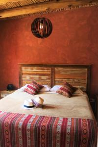 Casatilcara Cabañas في تيلكارا: غرفة نوم بسرير كبير وبجدران حمراء