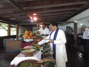 un hombre sosteniendo un plato de comida en un buffet en Oruthota Chalets, en Kandy