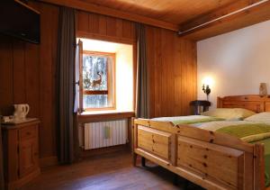 1 dormitorio con 2 camas y ventana en Baita Luleta, en Livigno