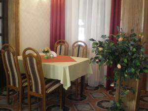 a dining room with a table and chairs and a plant at Zajazd Tip Top in Iganie