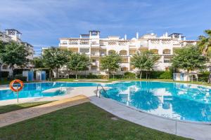 a swimming pool in front of a large building at Residencial Duquesa 18 in Manilva