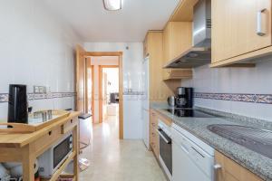 a kitchen with wooden cabinets and a counter top at Residencial Duquesa 18 in Manilva