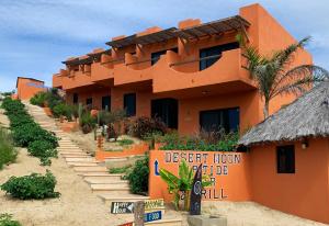 un edificio naranja con un letrero delante de él en Cerritos Beach Hotel Desert Moon, en El Pescadero