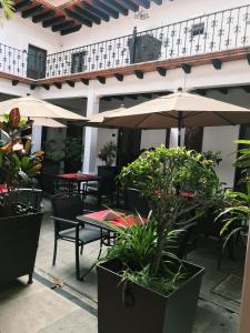 an outdoor patio with tables and chairs and umbrellas at Hotel Casa las Mercedes in Oaxaca City