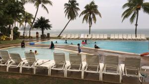 - une piscine avec des chaises et l'océan en arrière-plan dans l'établissement Reco Homestay@ The Regency Tanjung Tuan Beach Resort Port Dickson Tepi Pantai, à Port Dickson