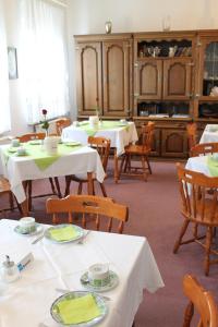 un comedor con mesas blancas y sillas de madera en Adler Hotel Dresden en Dresden
