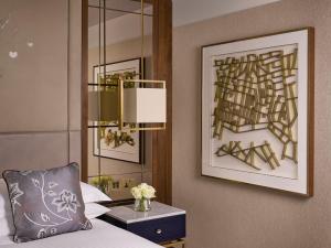 Un dormitorio con una cama, una lámpara y un espejo. en InterContinental London Park Lane by IHG, en Londres 225 fotos más