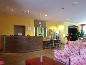 ein Wohnzimmer mit 2 Sofas und einer Bar in der Unterkunft Nashira Kurpark Hotel -100 prozent barrierefrei- in Bad Herrenalb