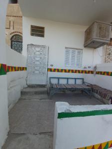 a white room with a bench and a door at Otasho Nile view house in Aswan