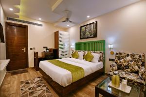 um quarto com uma cama grande e um sofá em Hotel Blue Pearl em Nova Deli