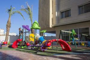 une aire de jeux en face d'un bâtiment dans l'établissement Second Home, à Amman