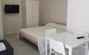 a room with two beds and a table and a tv at Casa Maria in Modica