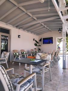 a patio with a table and chairs and a tv at Ipanema Hotel in Tigaki