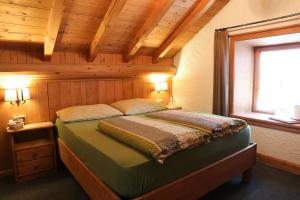 um quarto com uma cama num quarto de madeira em Baita Luleta em Livigno