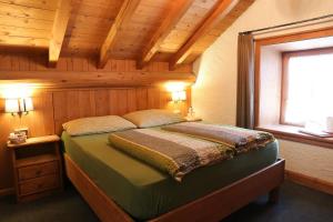 1 dormitorio con 1 cama en una habitación de madera en Baita Luleta, en Livigno