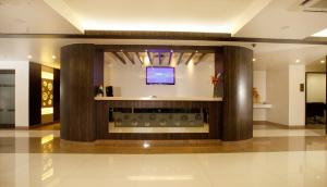 a lobby with a flat screen tv in a building at BIZZ Tamanna Hotel in Pune