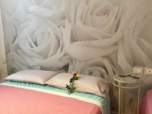 1 dormitorio con un mural de rosas en la pared en New Alex Home. Al Teatro., en Livorno