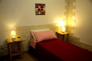 a bedroom with a bed and two lights on two tables at Biddanòa Bed and Breakfast in Cagliari