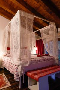 een slaapkamer met een hemelbed en gordijnen bij Country Home B&B Il Melo in Vicenza