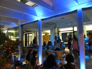 un grupo de personas sentadas en un restaurante por la noche en Hotel Gambrinus, en Riccione