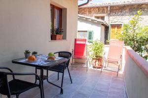 a patio with a table and chairs on a balcony at Casa per la Costa in Colle di Val d'Elsa