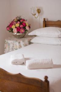 two beds with towels and a bowl of flowers at Camdeboo Cottages in Graaff-Reinet
