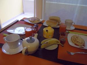 einen Tisch mit Teller mit Lebensmitteln und Bananen drauf in der Unterkunft Basic Hotel in Mindelo