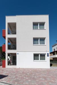 un edificio bianco con finestre e cielo blu di Apartment House Ivan John a Podstrana