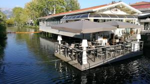 a boat with tables and umbrellas on the water at Casa Bianca in Marina di Massa