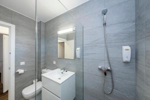 a bathroom with a shower and a toilet and a sink at Apartamentos Llebeig in Ciutadella