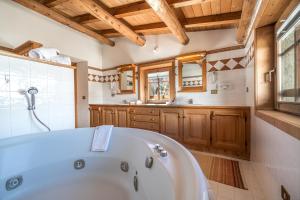 un ampio bagno con vasca e lavandino di Baita Luleta a Livigno