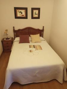 Un dormitorio con una gran cama blanca con dos almohadas. en Casa Ayabe, en Jaurrieta