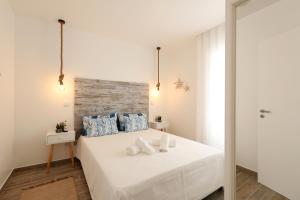 a bedroom with a large white bed with blue pillows at Sea & Sun Apartment II in Nazaré