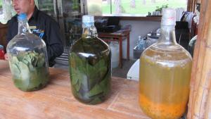 twee flessen alcohol zittend op een houten tafel bij Guizado Portillo Hacienda & Resort in Lunahuaná