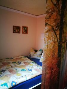 a bedroom with two beds and a tree at Ferienwohnung am Finkenherd in Dankerode