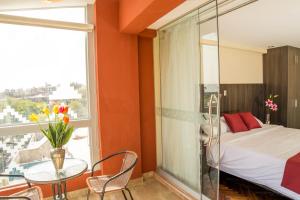 um quarto com uma cama, uma mesa e uma janela em Hotel Incamin Mirador em Arequipa