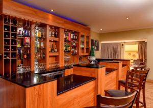 a bar with wooden cabinets and black counter tops at Lotus by Serendib in Blantyre