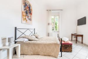 biała sypialnia z łóżkiem i telewizorem w obiekcie Lia Apartment w mieście La Spezia