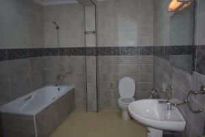 a bathroom with a tub and a toilet and a sink at HOTEL MENABE in Morondava