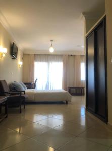 a bedroom with a bed and a couch and a window at HOTEL MENABE in Morondava