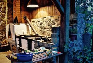 a stone wall with a stove and a table at Kozí Farma U Nýdrlů in Stará Červená Voda