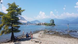 a group of people standing on the shore of a lake at Guest House Seme Di Faggio in Miasino