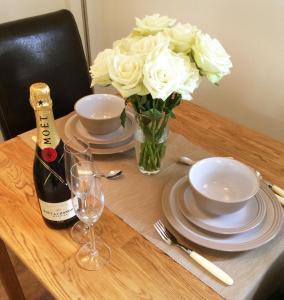 a table with a bottle of champagne and a vase of flowers at The Granary in Braunton